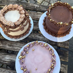Three decorated cakes on a wooden surface